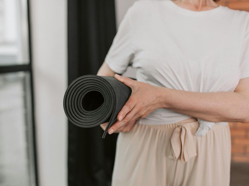 Detailed close-up of yoga mat and focused practitioner hands.